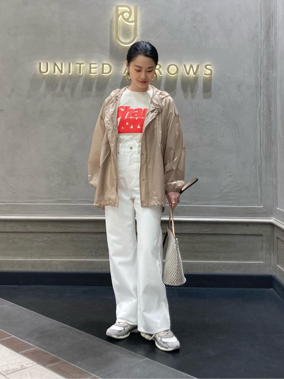ナイロンジャケットとロゴTシャツを着た女性