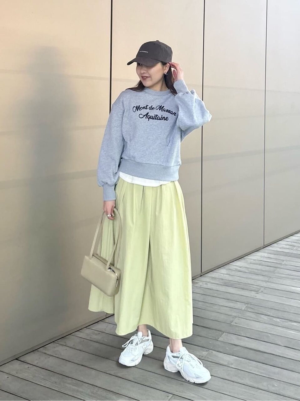 スウェットとフレアスカートを着た女性
