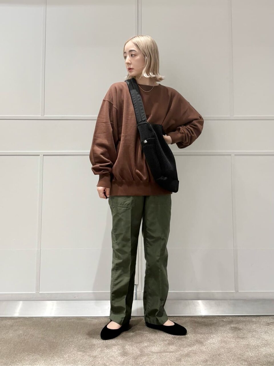 ブラウンのスウェットとカーキのパンツを着た女性