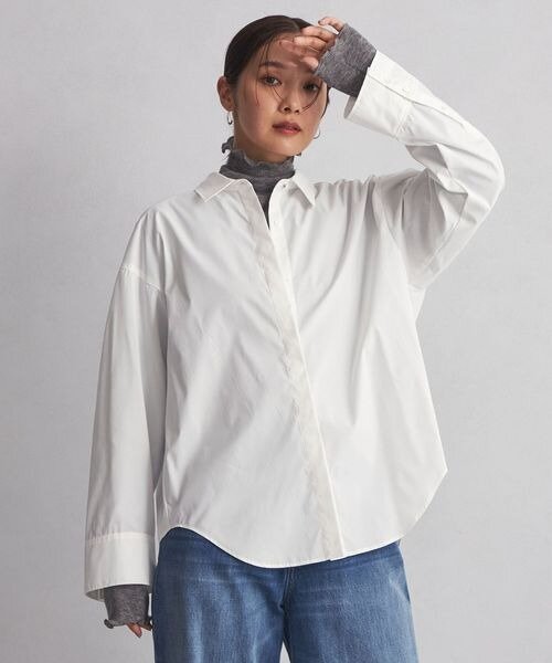 白シャツに異素材のインナーを着た女性