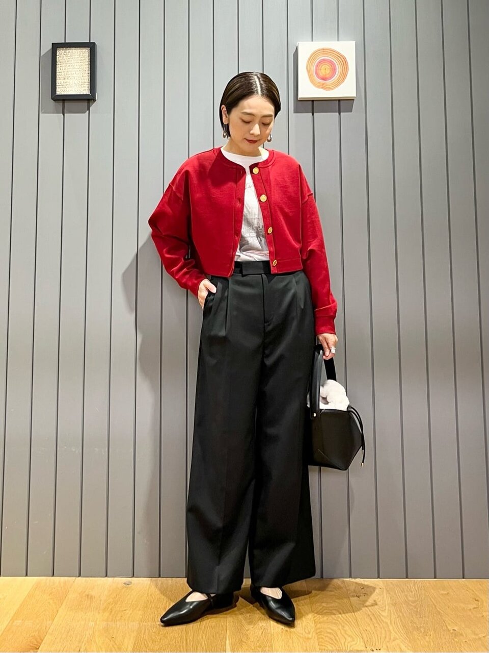 赤いカーディガンとパンツの女性