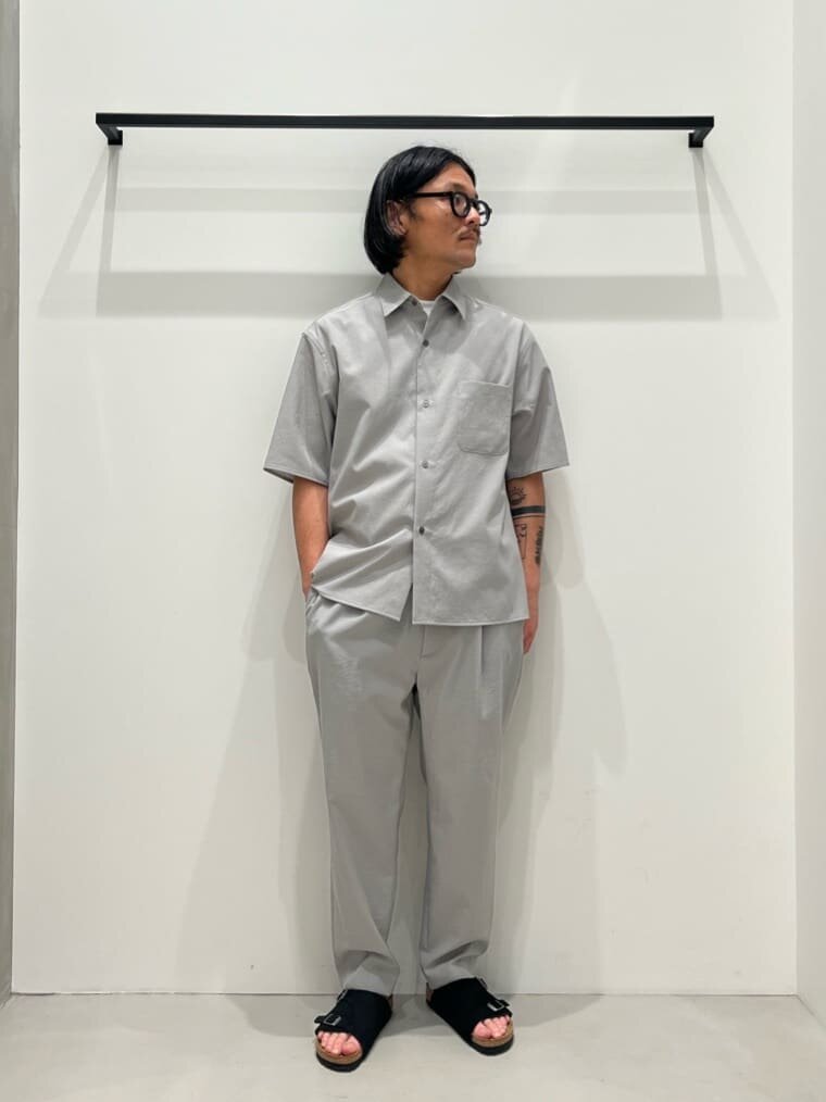 グレーの半袖シャツとパンツをセットアップで着た男性