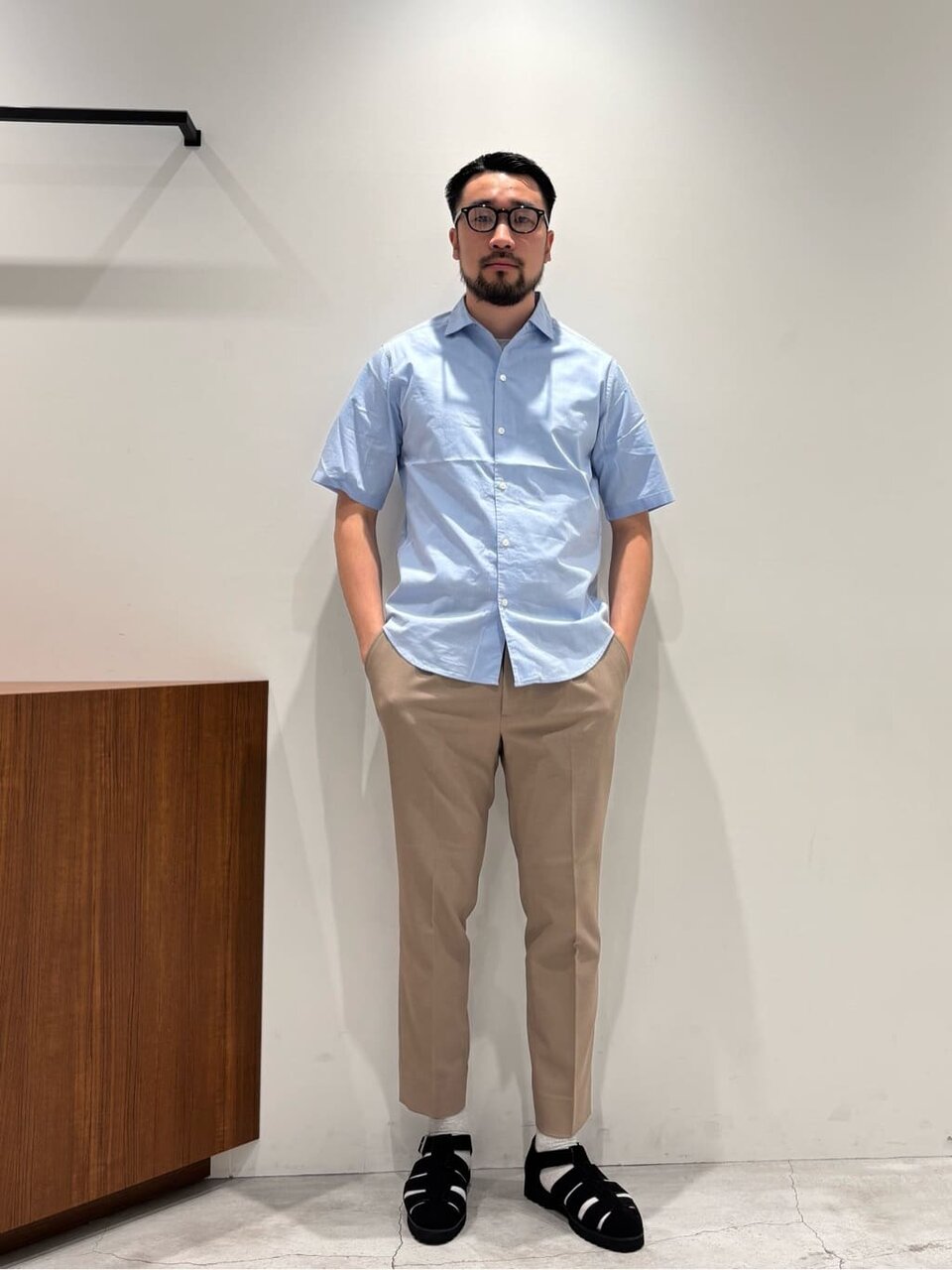 ブルーのシャツとベージュのパンツを着た男性