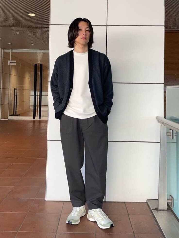 Vネックカーディガンとイージーパンツを着た男性