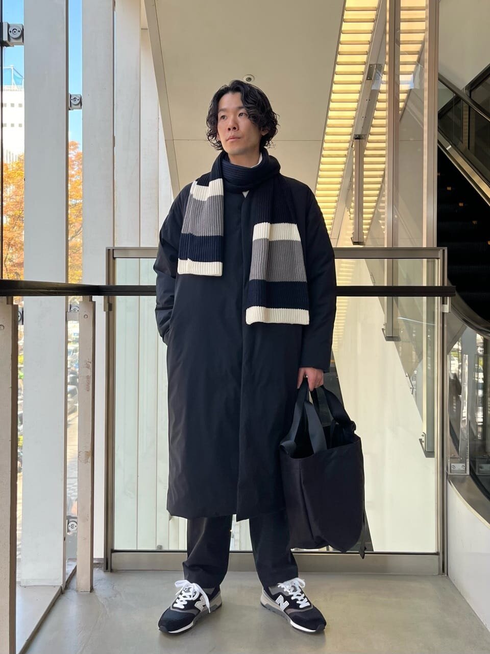 ダウンロングコートとマフラーをあわせた男性