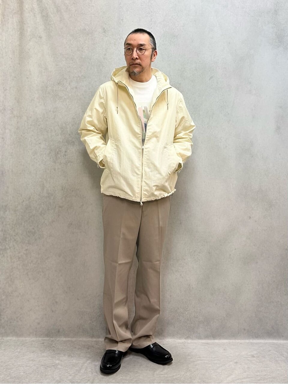 白のデッキパーカーとチノパンを着た男性