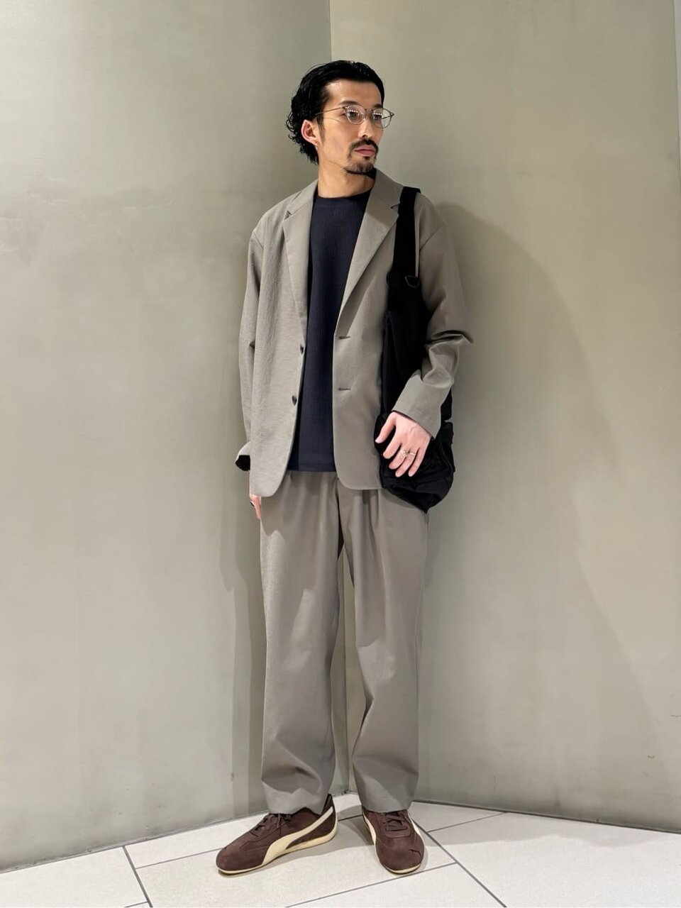 ジャケットとテーパードパンツを着た男性