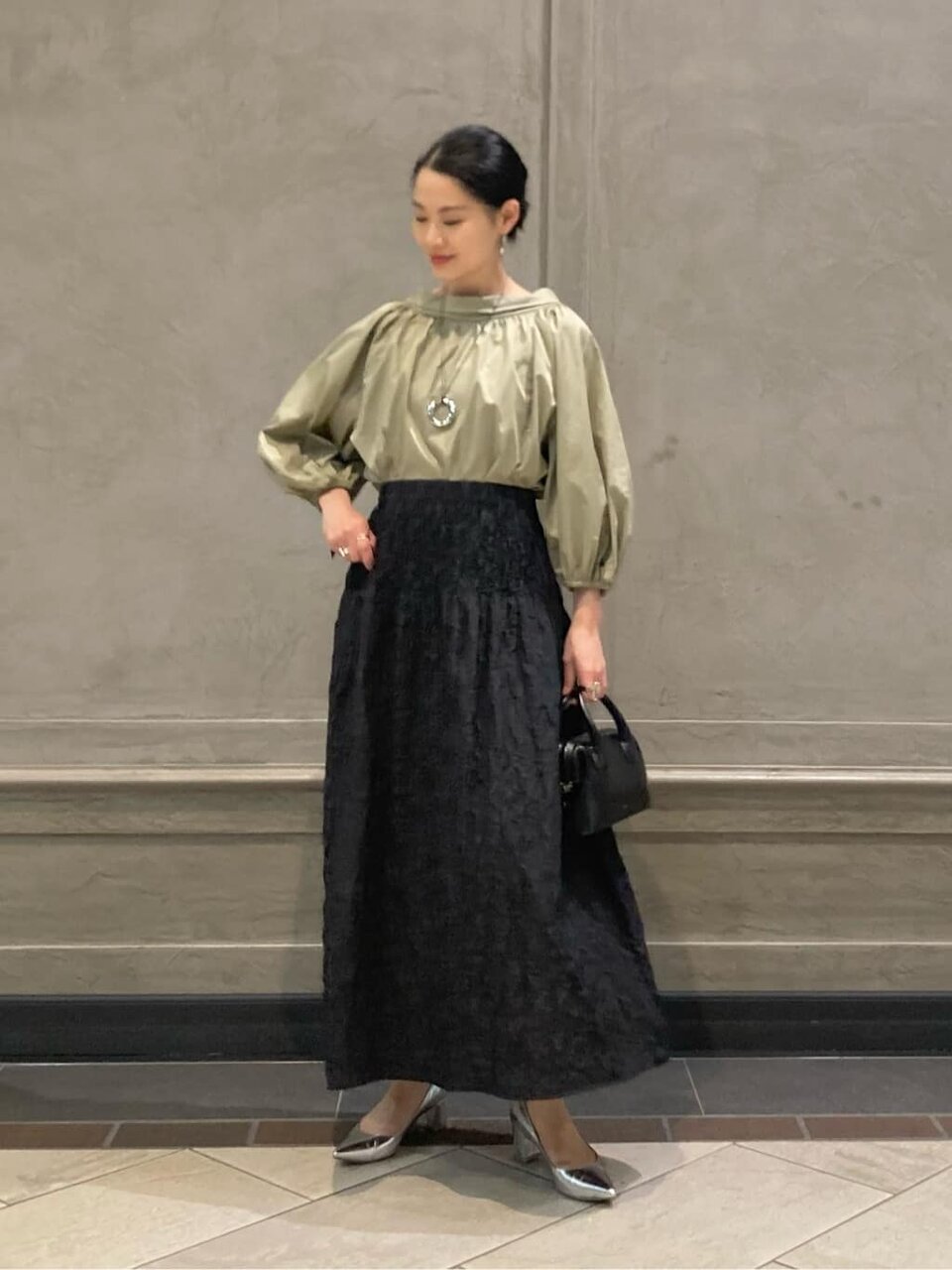 ギャザーブラウスとフレアスカートを着た女性