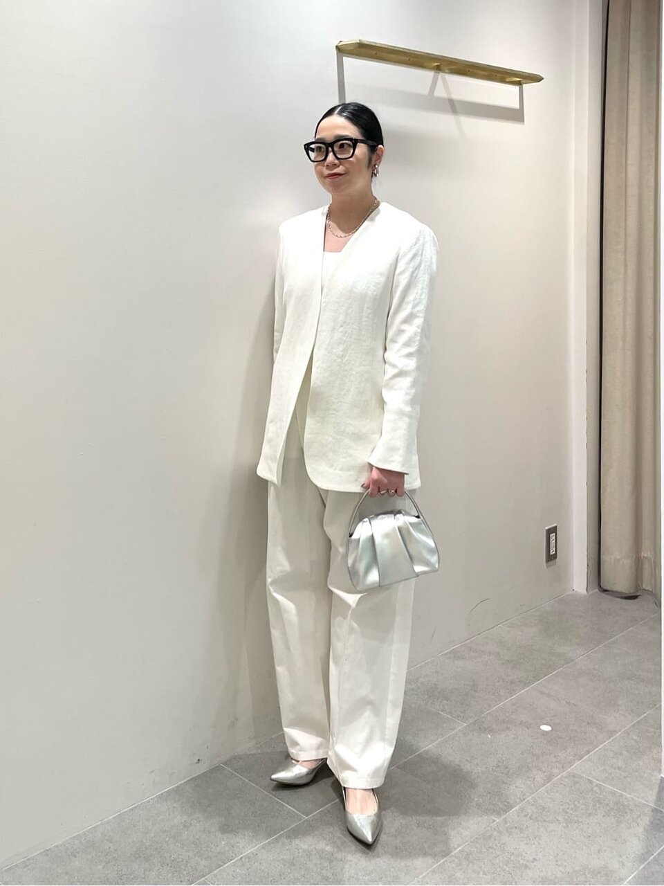 ノーカラーベストとオールインワンを着た女性