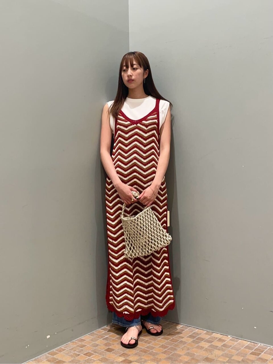 ノースリーブとニットキャミワンピースを着た女性