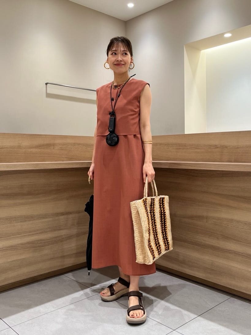 ジレとキャミワンピースを着た女性