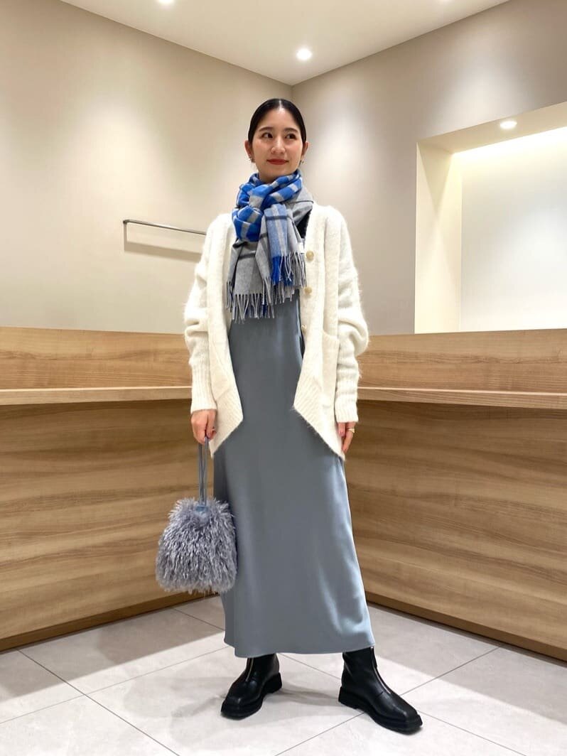 キャミワンピースとニットカーディガンを着た女性