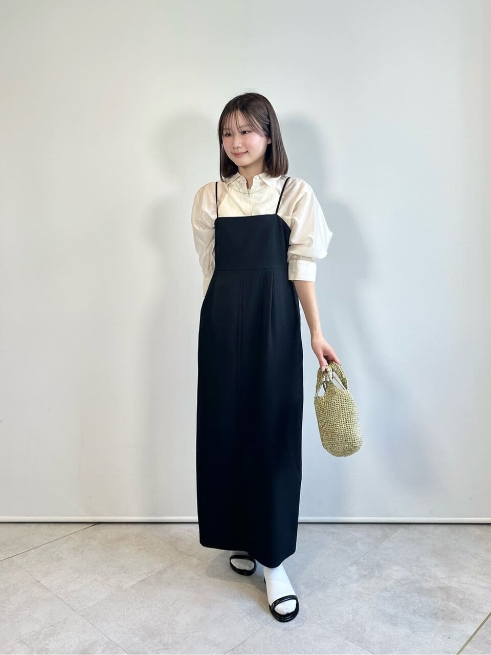 シアーシャツとキャミワンピースを着た女性