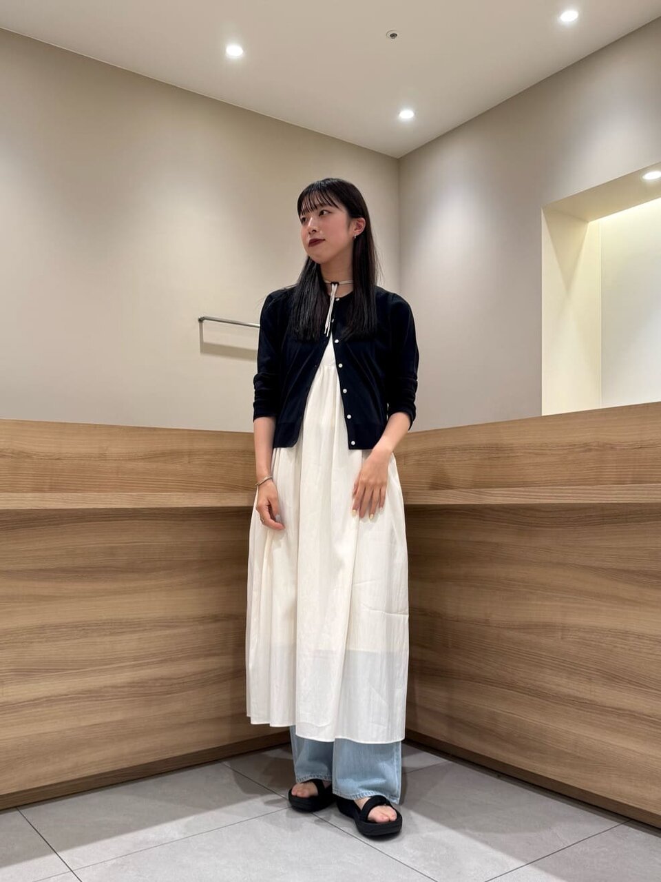 カーディガンとキャミワンピースを着た女性