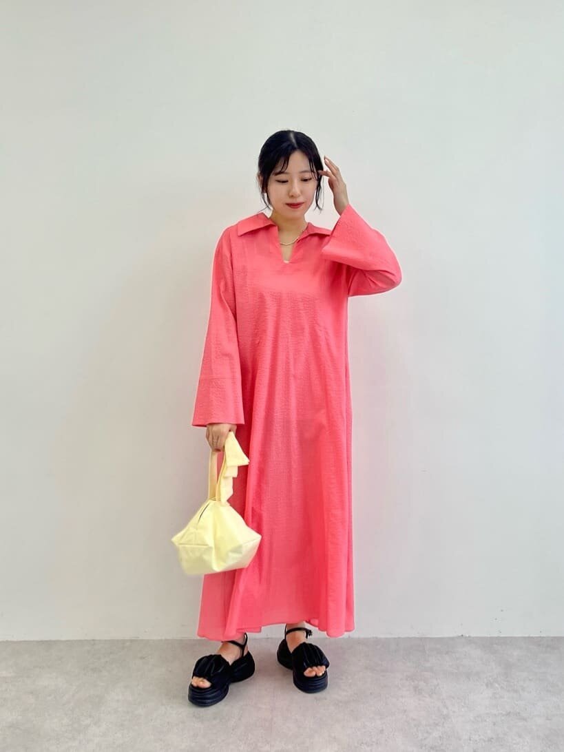 ピンクのシャツワンピースを着た女性