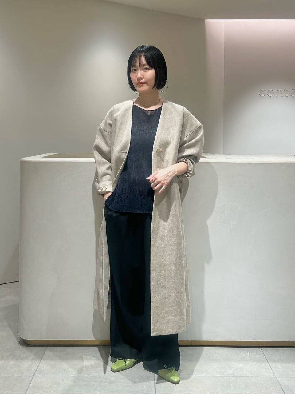 ノーカラーコートを着た女性