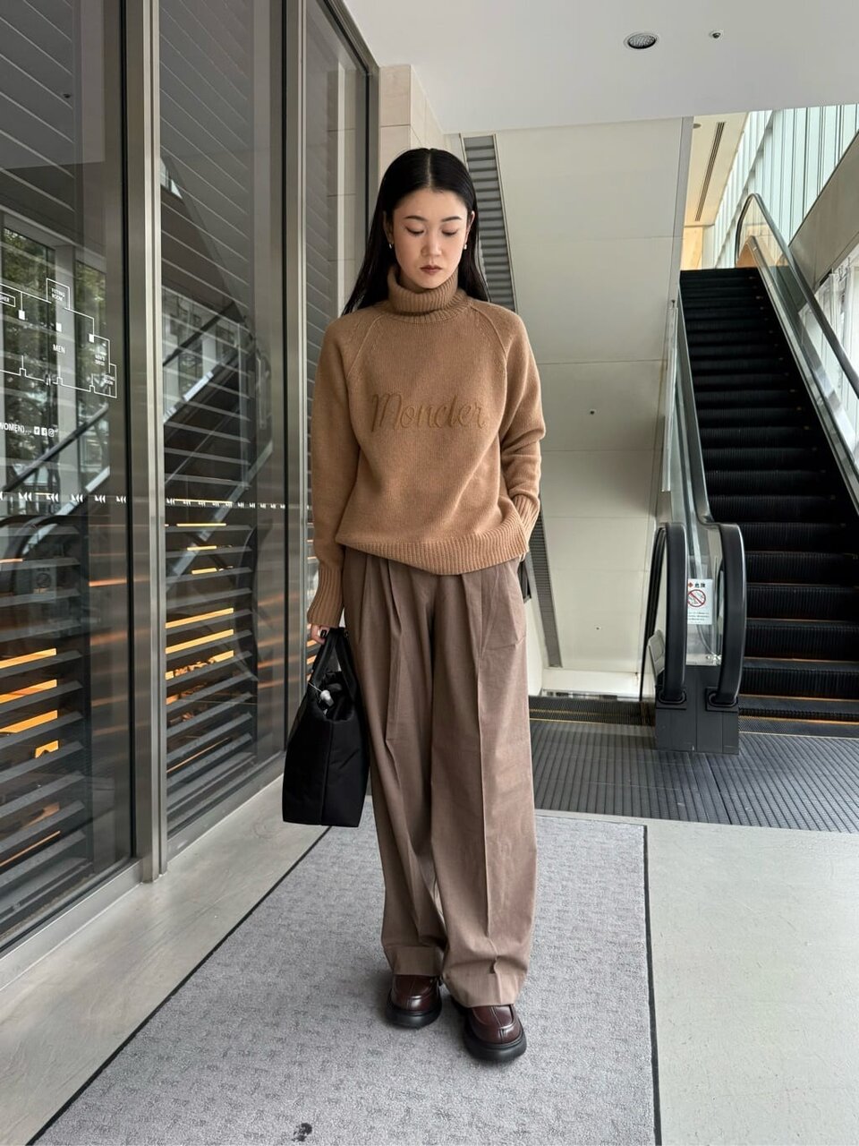 黒いベストとオリーブのパンツを着た女性