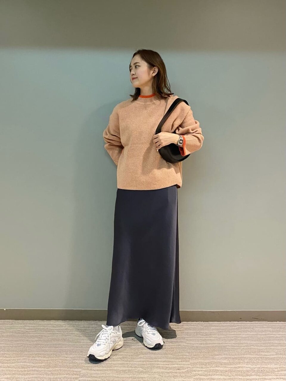 黒いベストとオリーブのパンツを着た女性