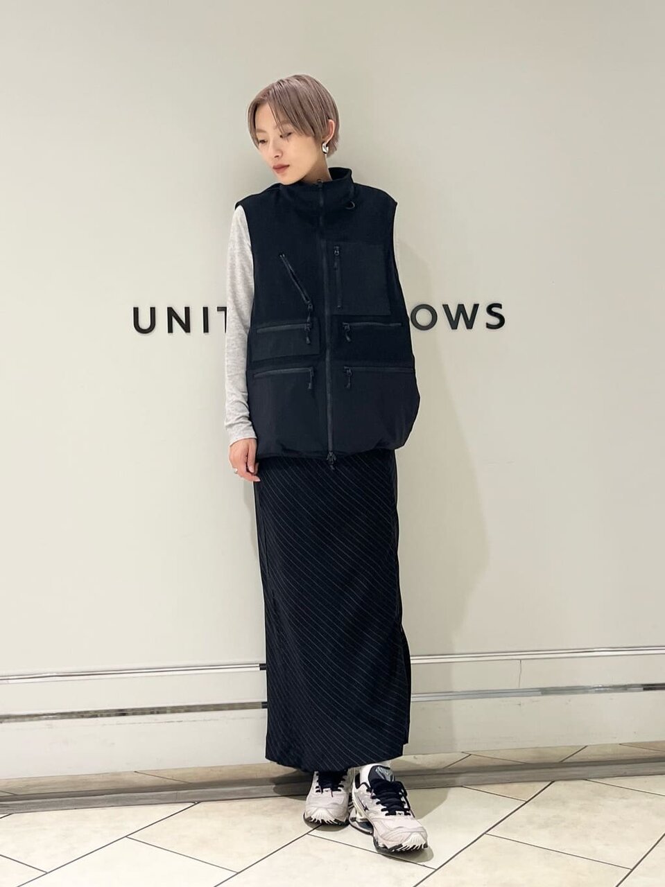 黒いベストとオリーブのパンツを着た女性