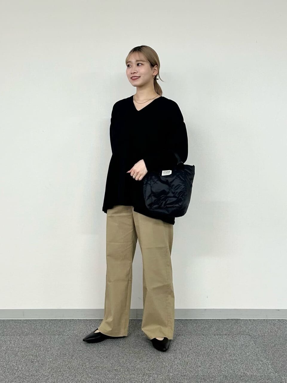 黒ニットとベージュパンツのコーデ