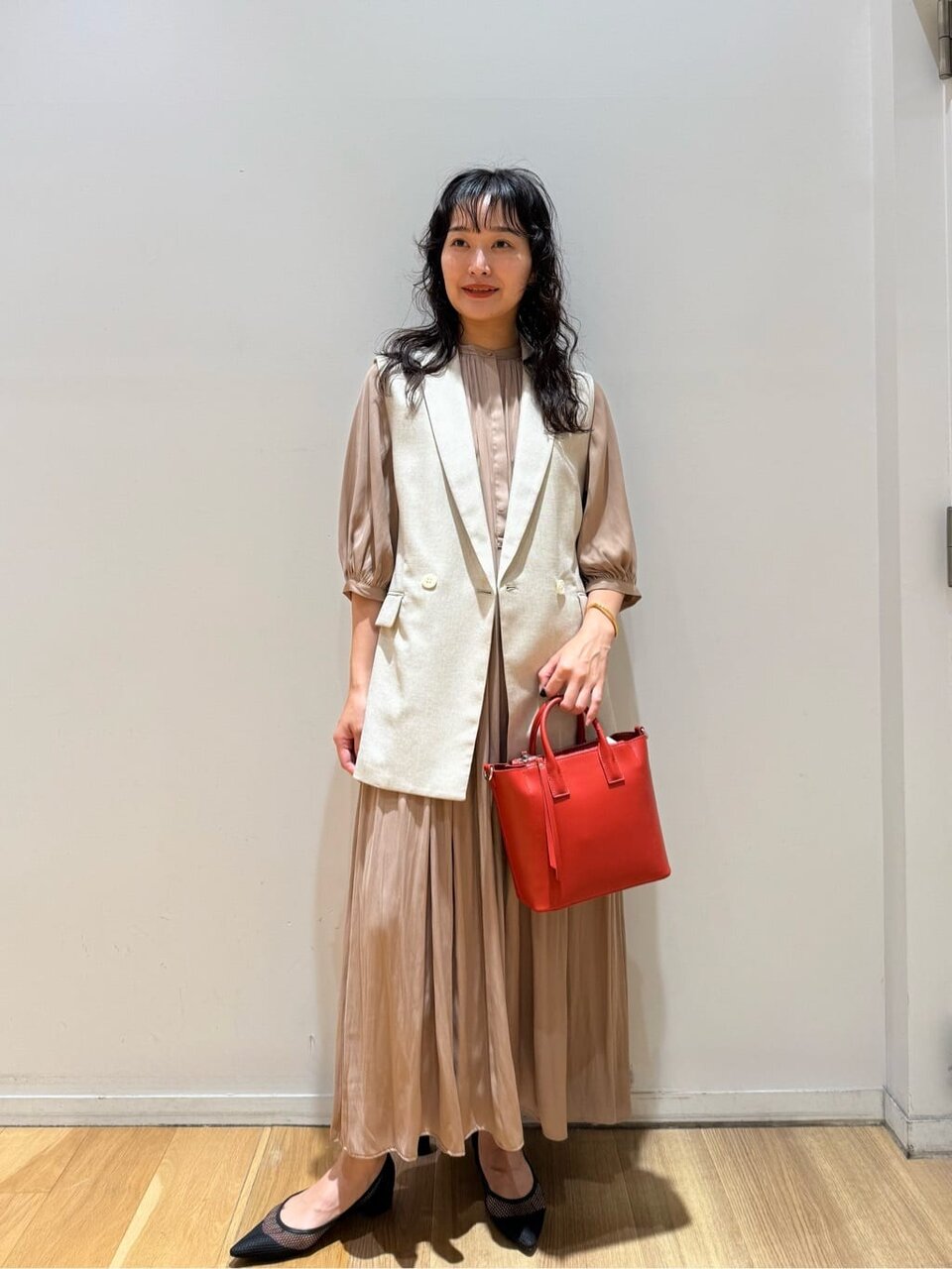 ワンピースにジレをあわせた女性