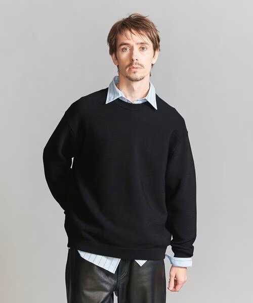 黒のニットを着用している男性
