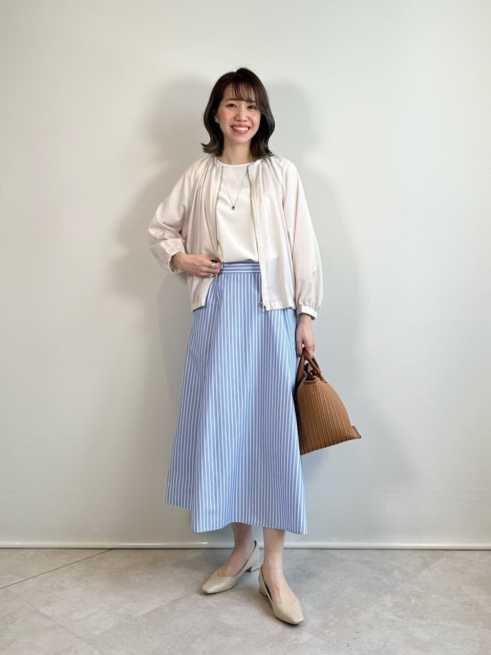 シアーブルゾンとフレアスカートをあわせた女性