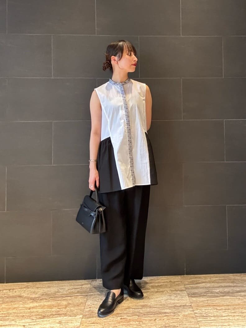 ノースリーブブラウスとローファーをあわせた女性