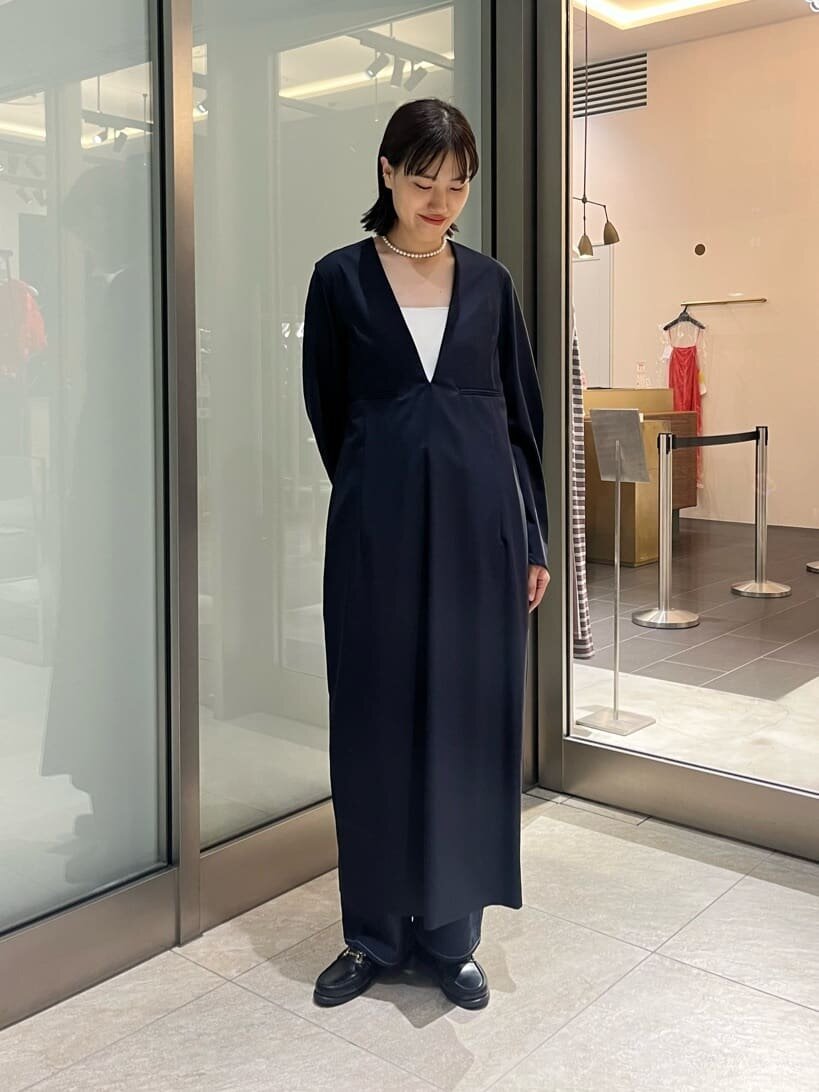 Vネックドレスとローファーをあわせた女性
