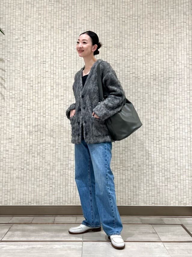 シャギーカーディガンと白のローファーをあわせた女性
