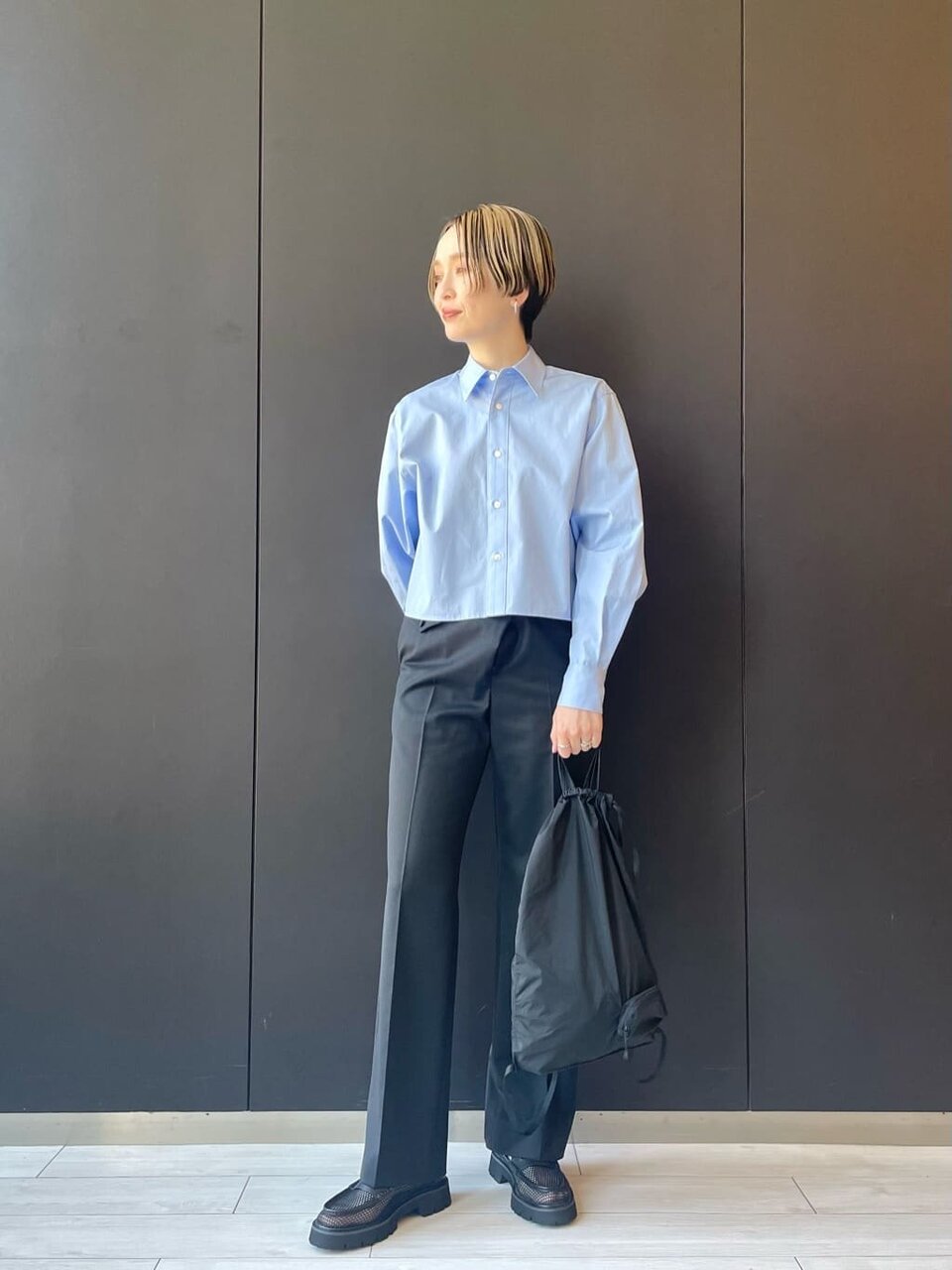 シャツとスラックスにローファーをあわせた女性