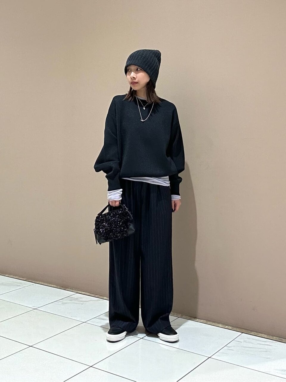 黒ニットにニットキャップをあわせた女性