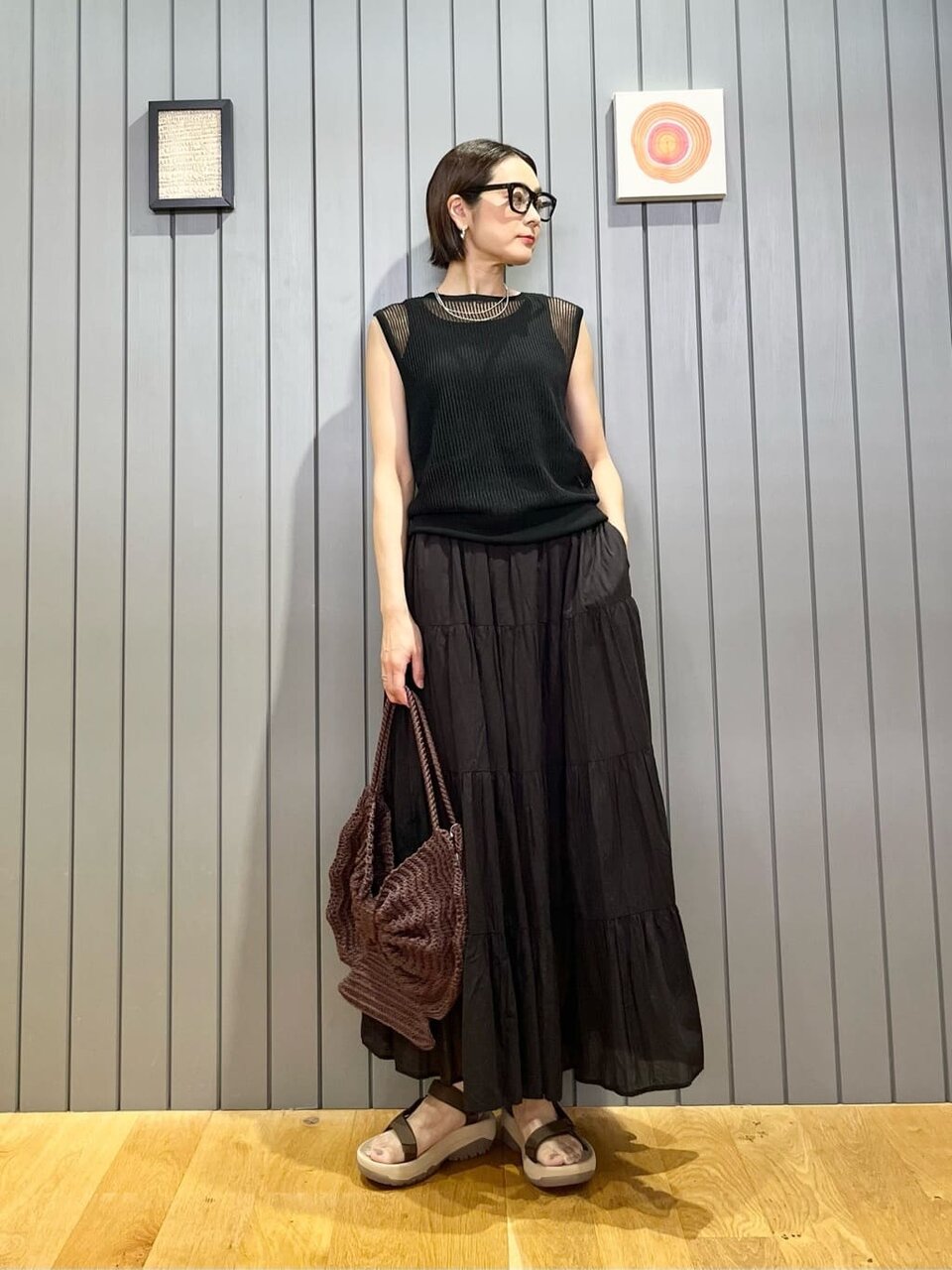 黒ニットとティアードスカートを着た女性