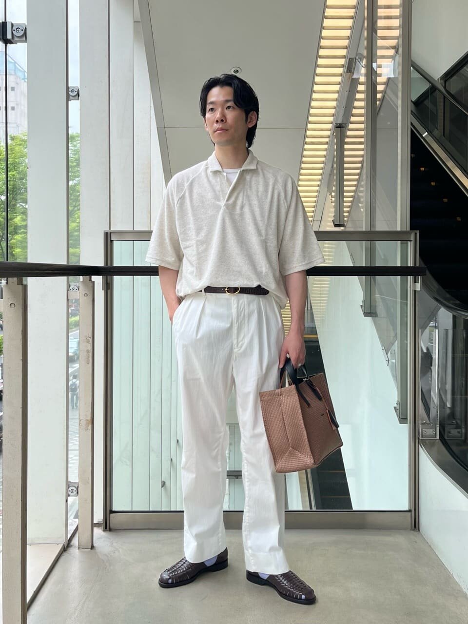 白のスキッパープルオーダーとチノパンを着た男性