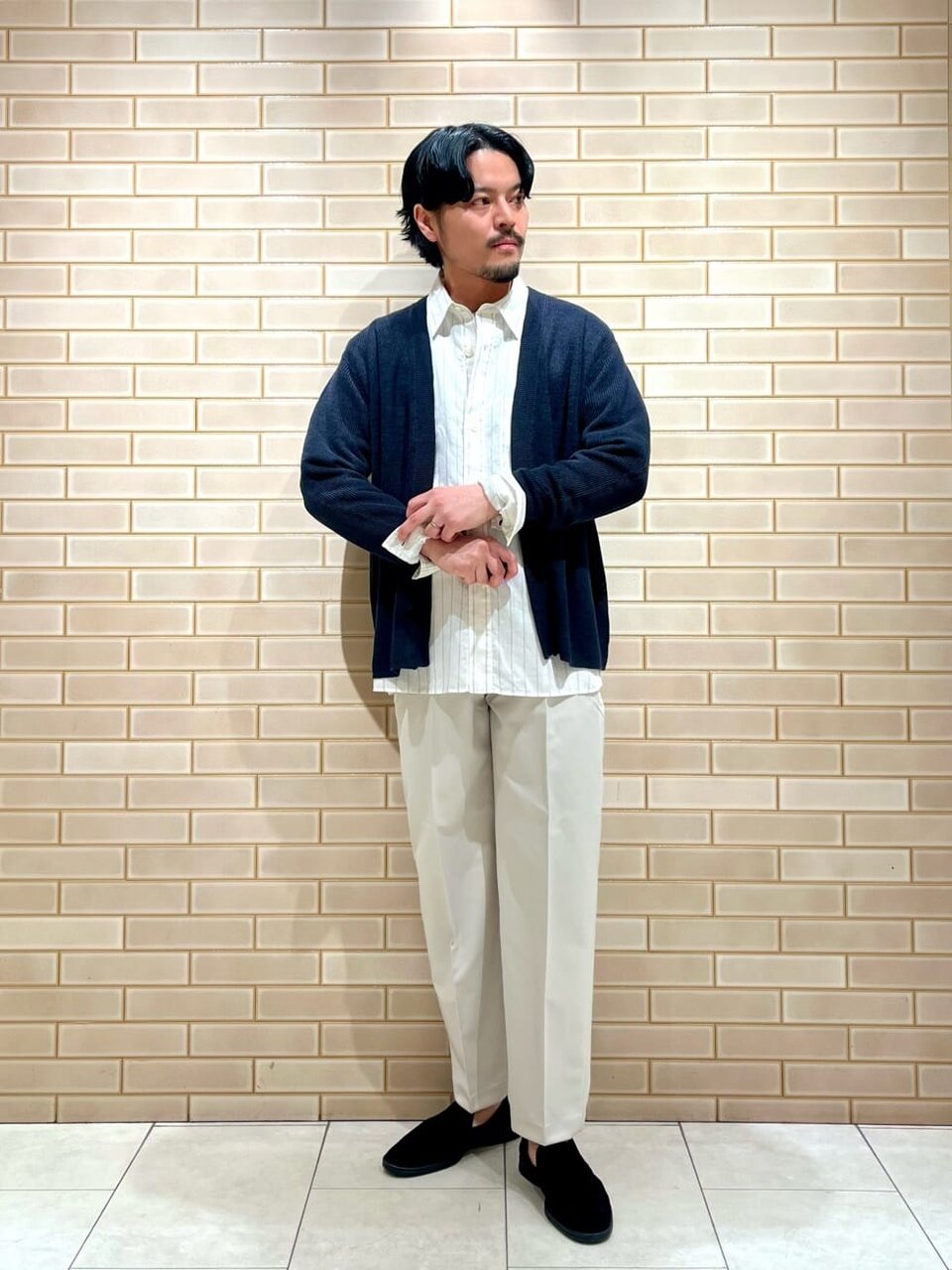 カーディガンとワイドパンツを着た男性