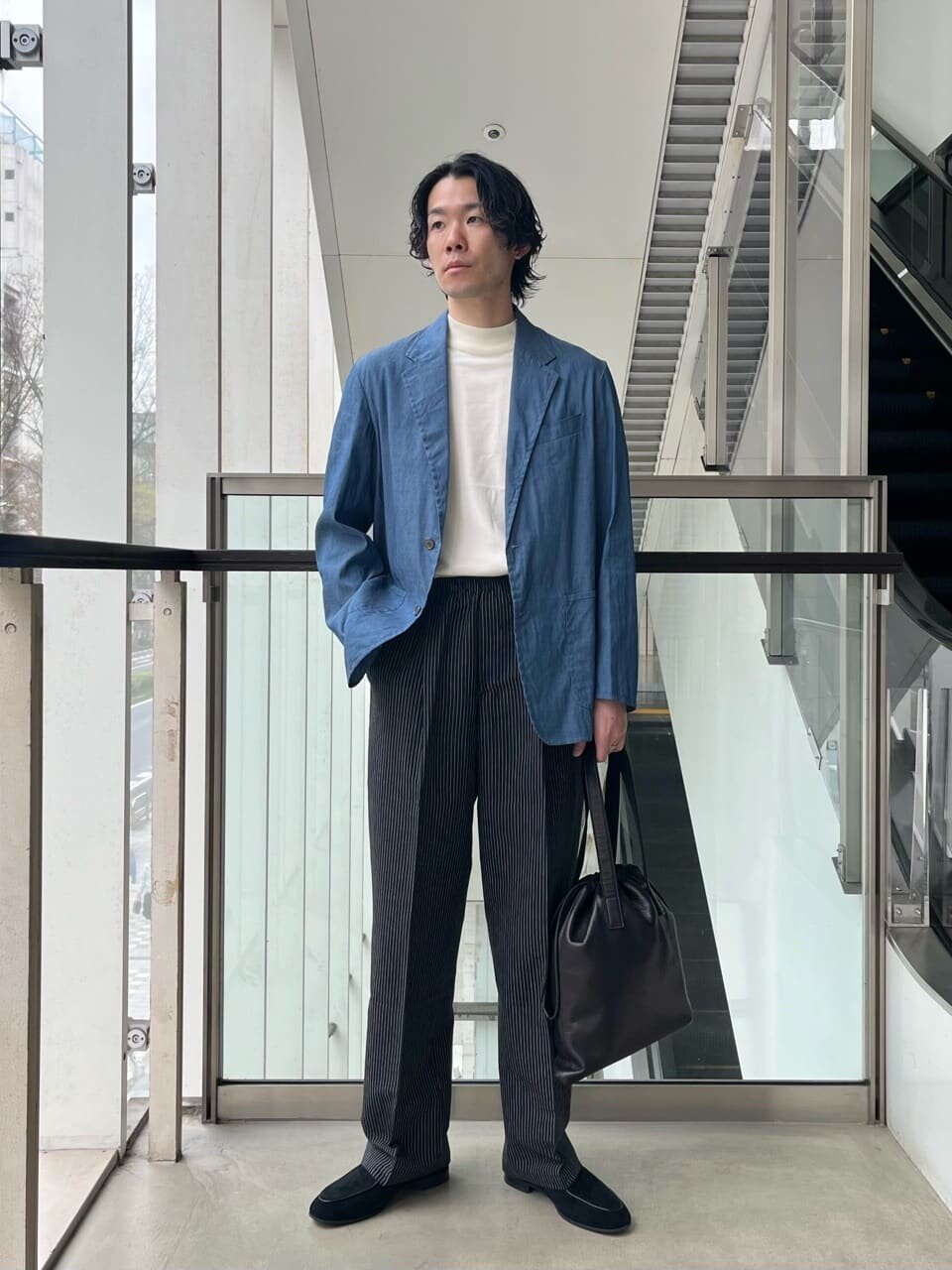 シャンブレージャケットとスラックスを着た男性