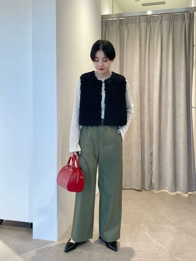 黒いベストとオリーブのパンツを着た女性