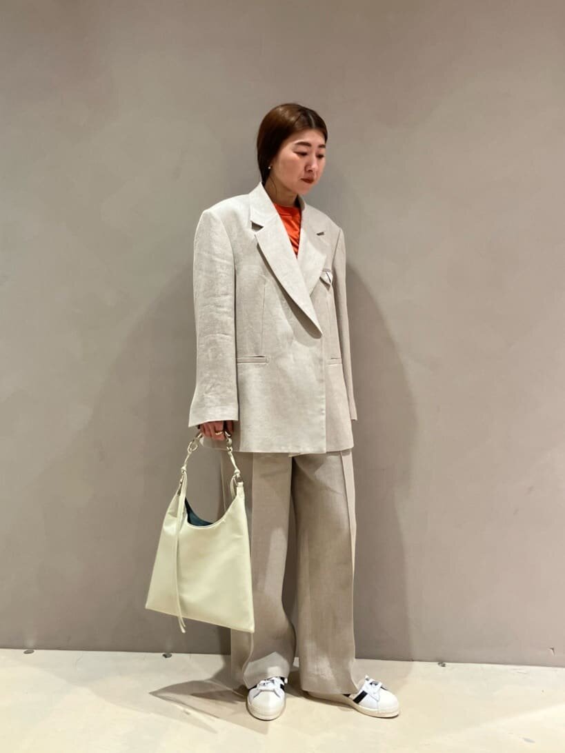 ジャケットセットアップとスニーカーを着た女性