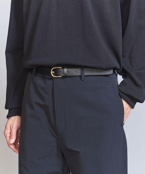 オーバル型バックルのベルトをした男性