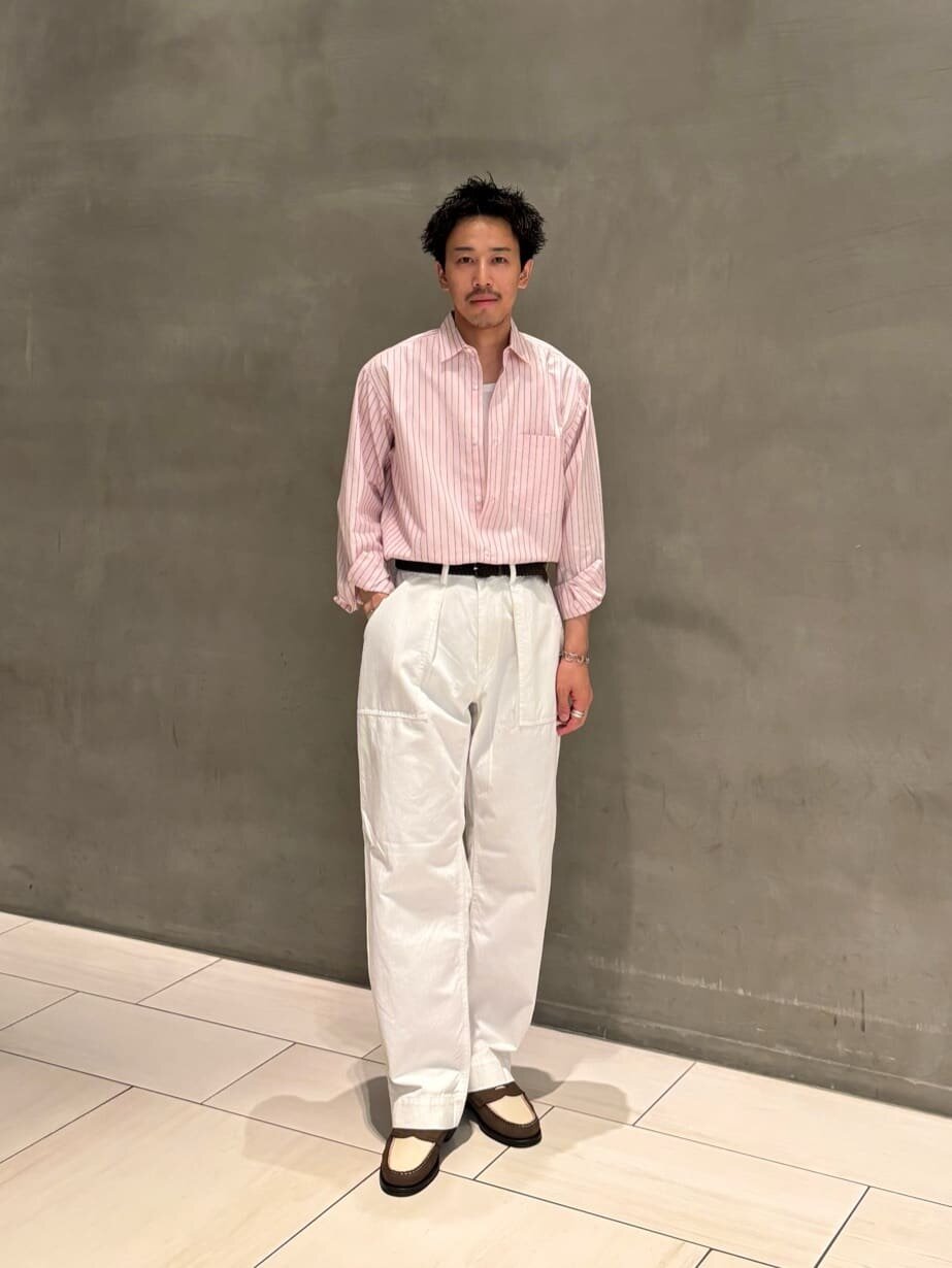 ライトピンクのシャツをタックインした男性