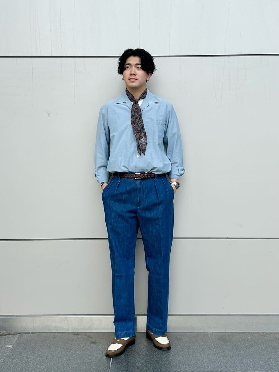 ライトブルーのシャツをタックインした男性