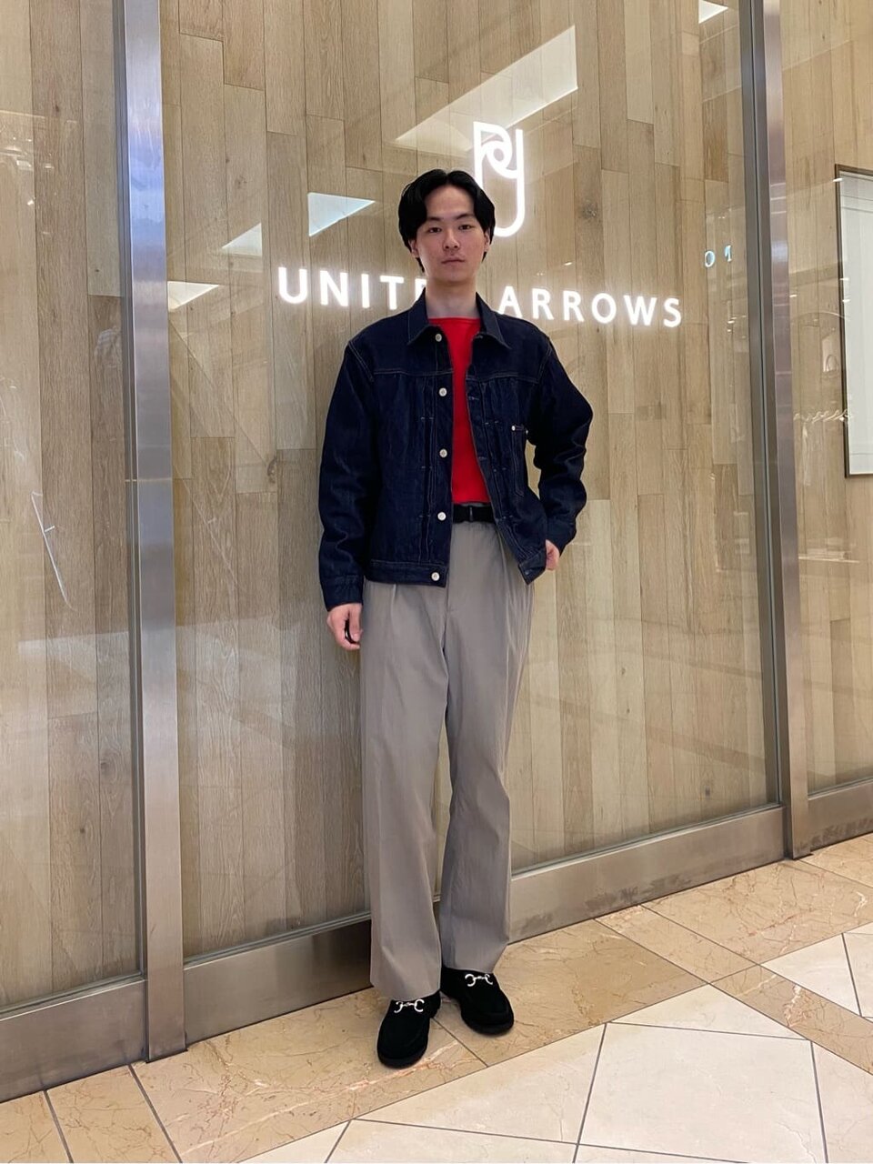 赤のシャツをタックインした男性