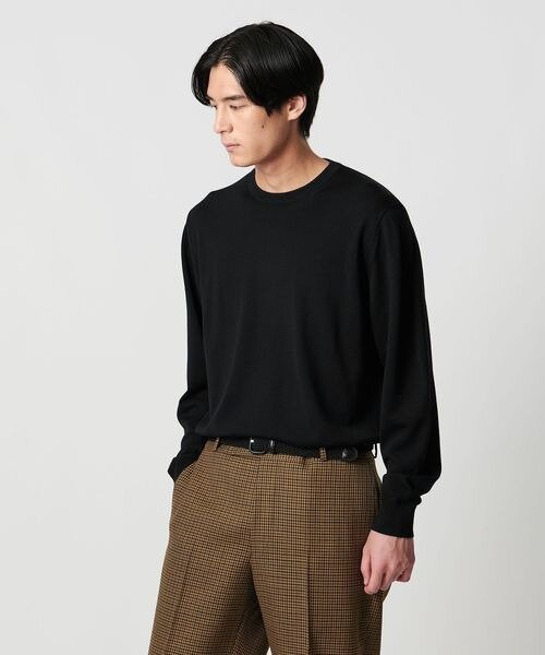 黒ニット×チェック柄パンツの男性
