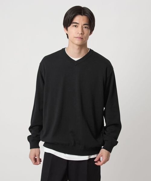 黒ニット×白のカットソーのレイヤードスタイル