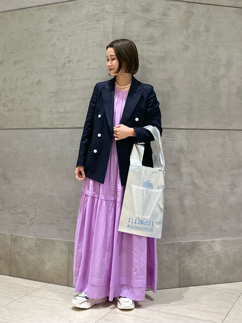テーラードジャケットとワンピースを着た女性