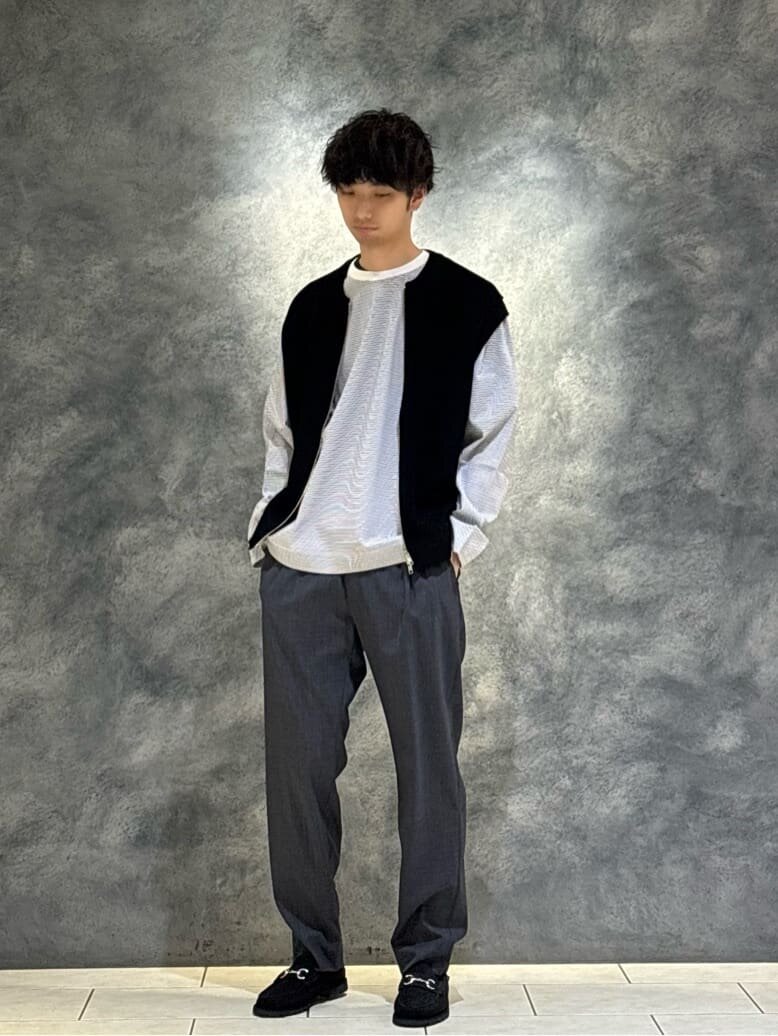 ベストとロングTシャツを着た男性