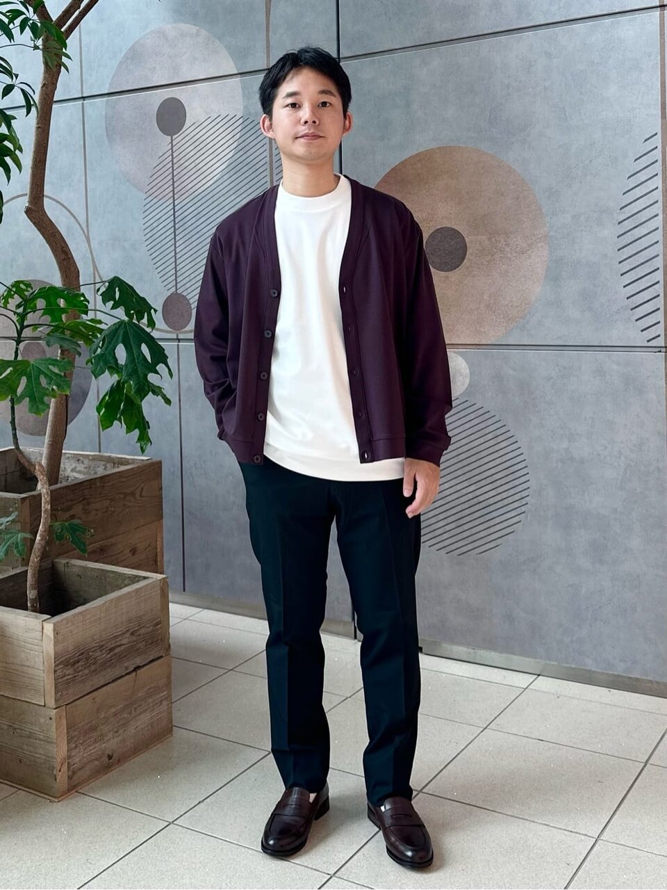 カーディガンとスラックスを着た男性
