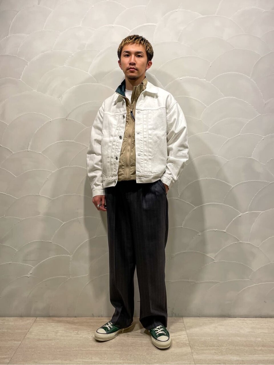 デニムブルゾンとベストを着た男性