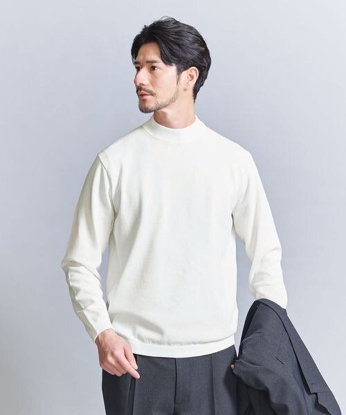 白ニットを着た男性