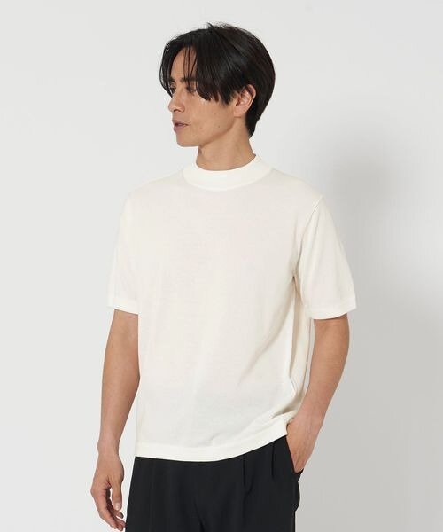 薄手の白ニットを着た男性